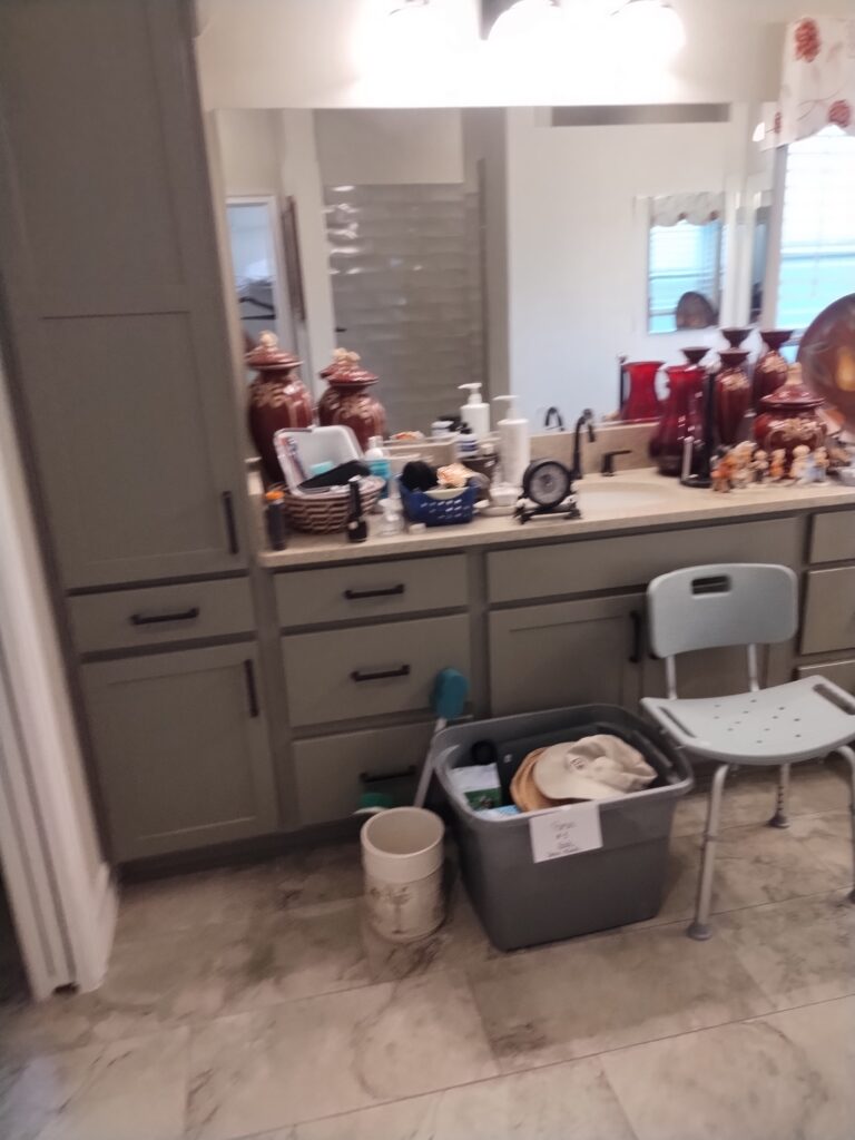 Bathroom clutter from estate cleanout including vases, junk items, and shower chair before removal in Central Florida