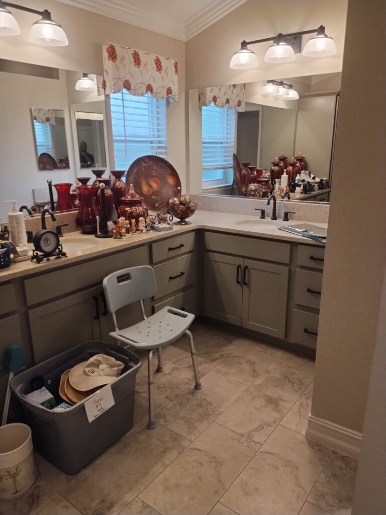 Cluttered bathroom during estate cleanout with vases, debris, and shower chair awaiting junk removal in Citrus County Florida